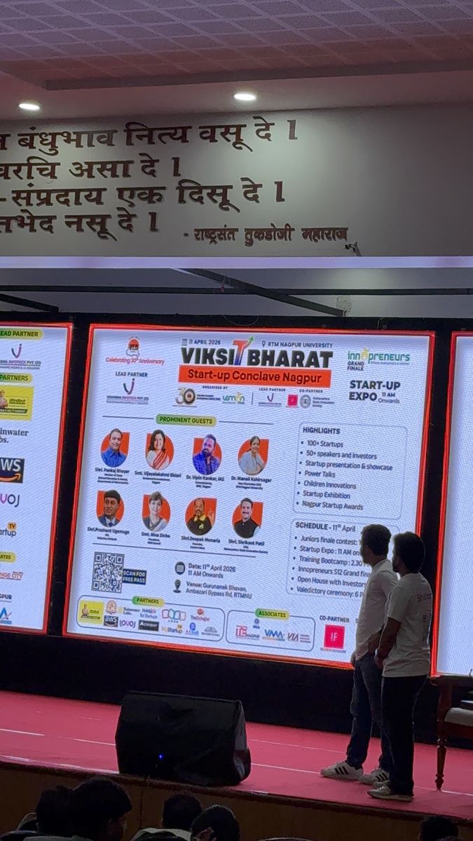 Nilansh and Archit on stage at RTMNU Nagpur auditorium with Viksit Bharat Innopreneurs Season 12 screen